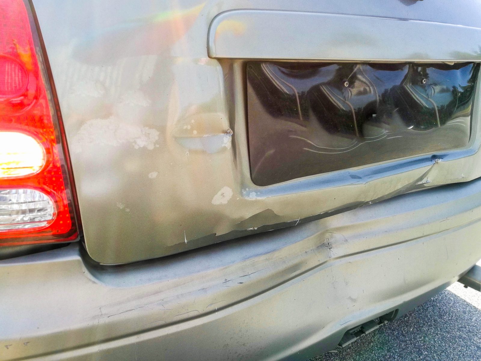 Close-up of a car's dented rear bumper damaged in a rear-end collision