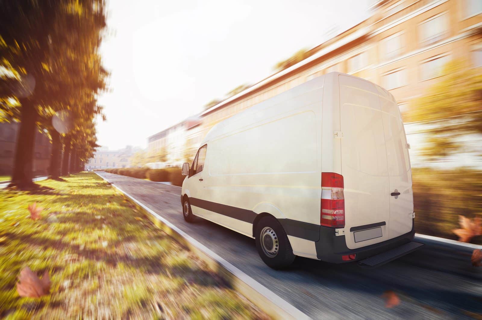 A white delivery van driving on a road, illustrating the surge of delivery vans behind van accident claims.