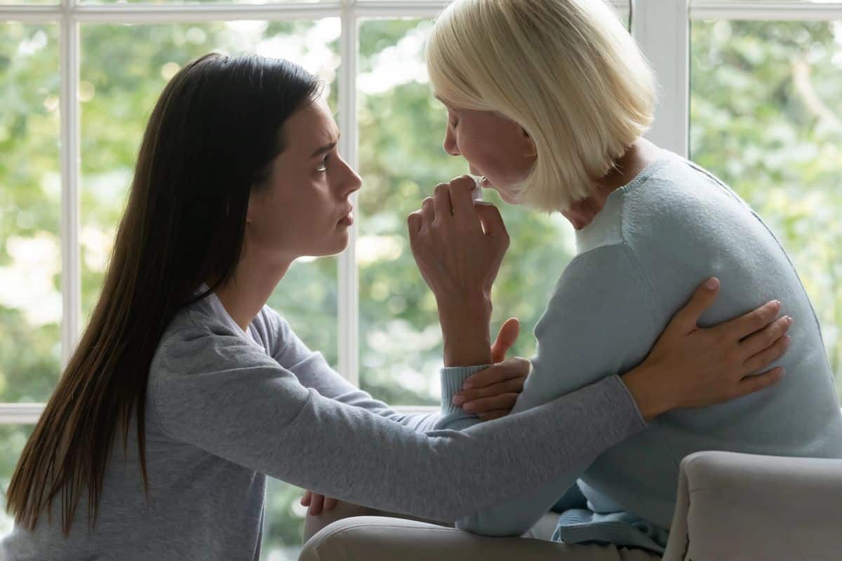 A young woman comforting a grieving older family member after the loss of a loved one in Olive Branch, Mississippi