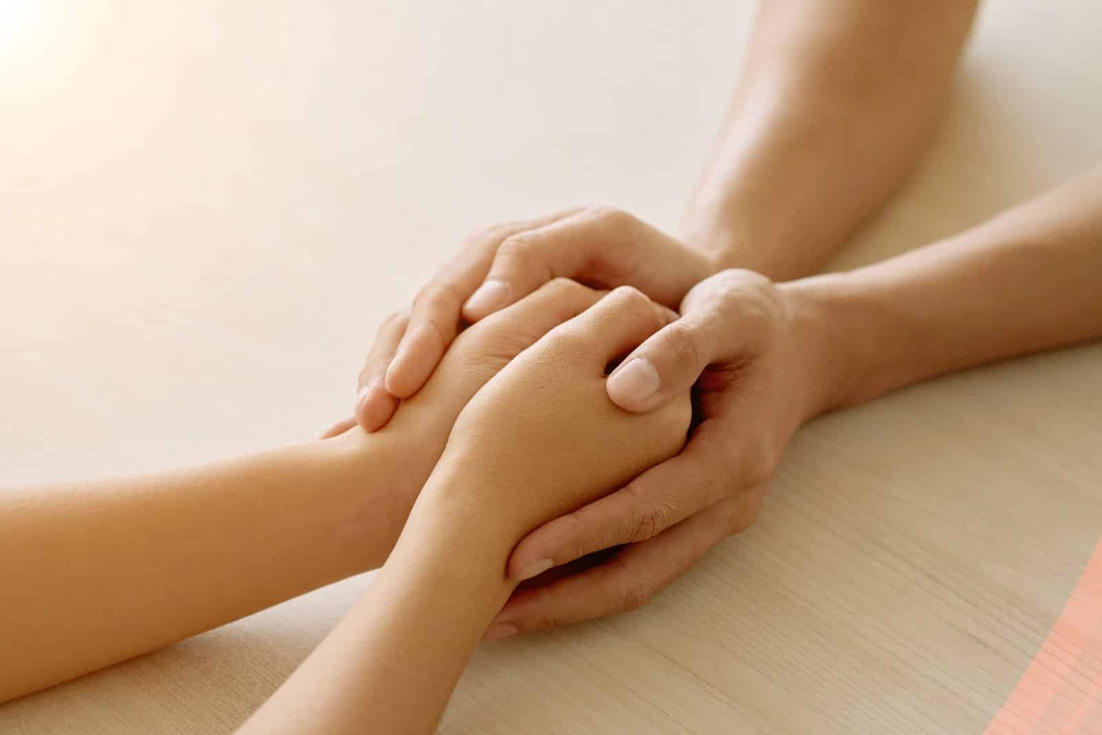 Two hands gently clasped in comfort and support, representing compassionate help for grieving families from Southern Injury Attorneys wrongful death lawyers.